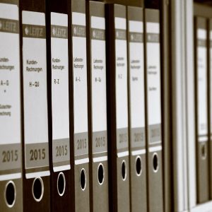 何一舟整理读者来信与 github文件加速 勘误记录表，桌面整齐摆放着信件与橙色标记笔，态度认真
